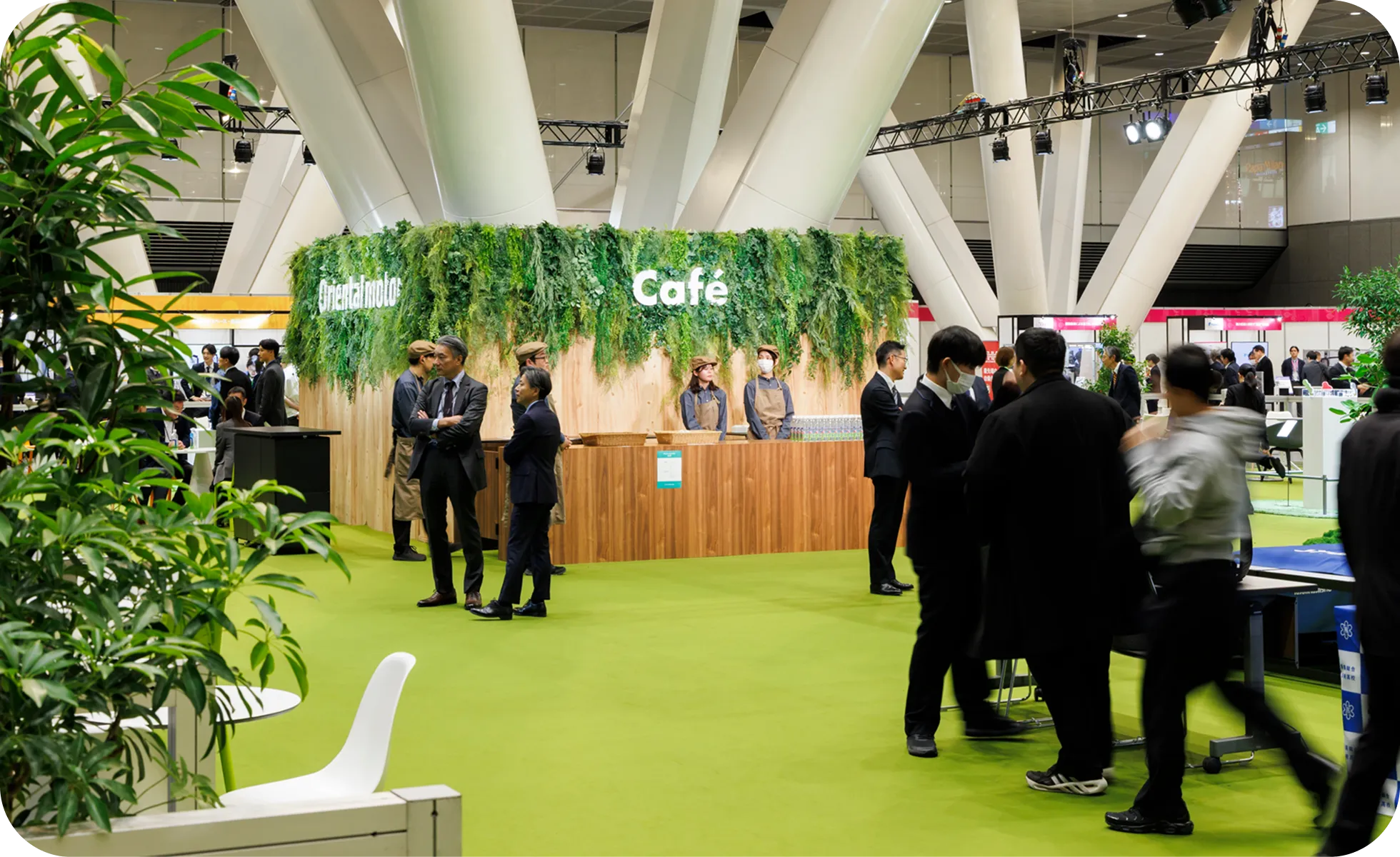 木目調の壁とグリーンの装飾がおしゃれな会場内のカフェコーナー。