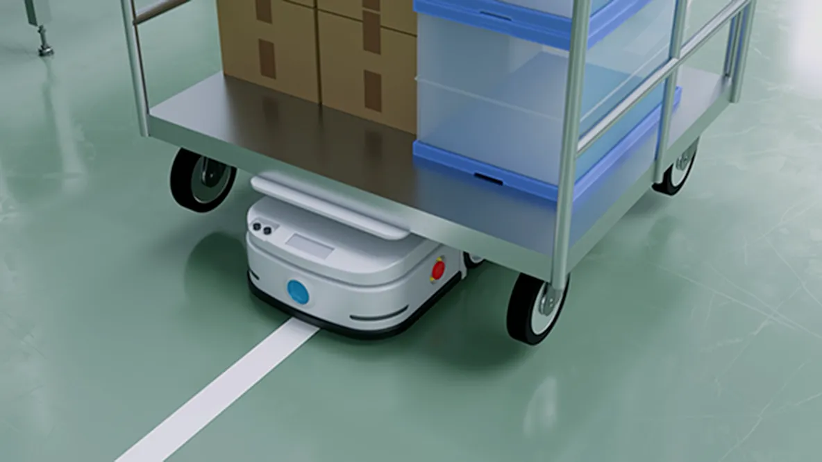 白い小型ロボットが青いコンテナと段ボール箱を載せたカートを牽引し、床の白いガイドラインに沿って移動している様子